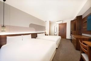 京都Hop Inn Kyoto Shijo Omiya的酒店客房配有两张床和一张书桌