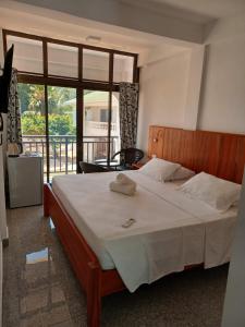 安塞奥潘嘉美拉海滩宾馆的一间卧室设有一张大床和大窗户