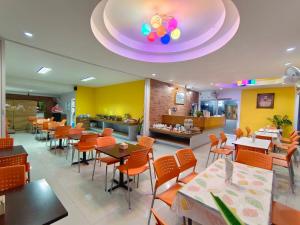 Ban Rai纳隆酒店的餐厅设有橙色桌椅和紫色天花板