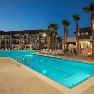 奥兰多Harry Potter Themed Luxury Apartment 3bd 2bth - Universal Studios的棕榈树和建筑的夜间游泳池