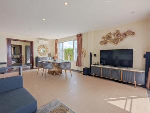 象岛马尼普拉别墅的客厅配有电视和桌椅