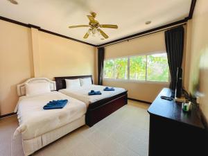 柴老海滩班发特来羌度假酒店的一间卧室配有两张床和吊扇