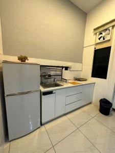 宾南邦SW Rental的厨房配有白色橱柜和水槽
