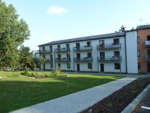 伏尔塔瓦河畔利普诺Harmonie Apartments的一座大型白色建筑,设有阳台和草坪