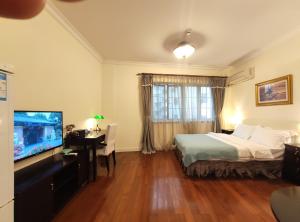 上海国际丽都公馆的酒店客房,配有床和电视