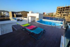 普拉亚Family villa: pool and panoramic view的坐在屋顶上的几把椅子