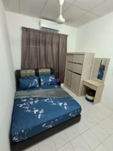日得拉Adempuri Homestay 3的一间卧室配有一张带鲜花的蓝色床