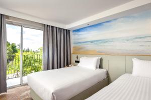 珀斯Aurea Hotel Perth Kings Park的配有窗户的酒店客房内的两张床