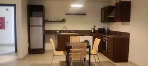安曼DeadSea view apartments Samarah Resort E22的厨房配有桌椅和水槽。
