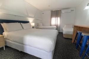 仙女港Caledonian Inn - The Stump的酒店客房设有一张白色大床和一张书桌