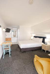 仙女港Caledonian Inn - The Stump的卧室配有1张床、1张桌子和1把椅子