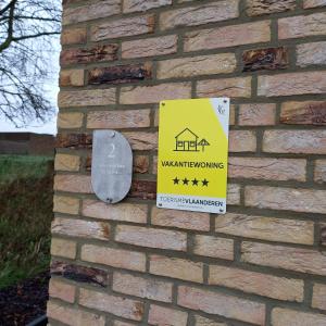 ZottegemDe Molenlos的砖墙边带有警告标志的标志