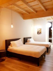奥尔塔圣朱利奥阿拉柯利酒店的配有木天花板的客房设有两张床。