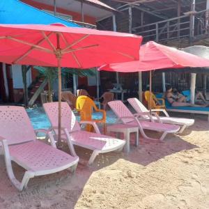布兰卡滩Playa Tortuga Cabaña的海滩上的一组椅子和遮阳伞