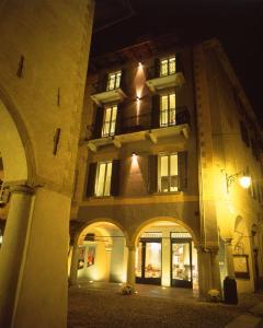 奥尔塔圣朱利奥阿拉柯利酒店的一座大型建筑,在晚上前方有拱门