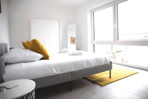SandweilerBeautiful 4BR House with Jacuzzi的一间卧室配有带白色床单和黄色枕头的床。