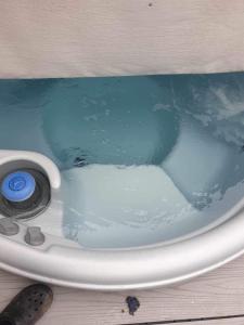 塔特舍尔hot tub luxury caravan 23 Lancaster tattershall lakes的浴缸里坐着蓝色的水,