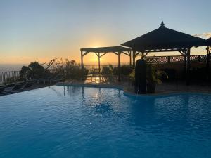 圣勒Residence Les Lataniers的一座享有日落美景的大型游泳池