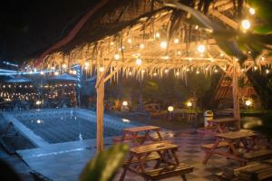 塞亚特New DGYP Ciater Resort的一组桌子和椅子,位于游泳池旁