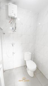 塞亚特New DGYP Ciater Resort的白色的浴室设有卫生间和淋浴。
