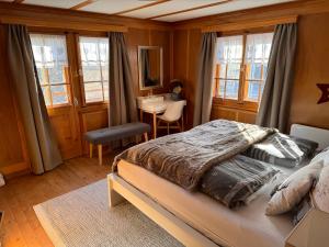 PeistBambi Lodge Ferienwohnung auf knapp 1400 m nahe Arosa的卧室配有一张床、一张书桌和窗户。