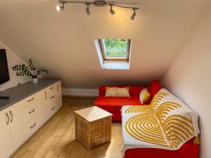 伦敦1 Bed Attic Flat with Easy Reach to City Centre的客厅设有红色的沙发和窗户。