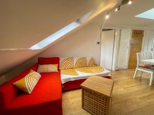 伦敦1 Bed Attic Flat with Easy Reach to City Centre的客厅配有红色的沙发和床。