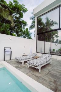 瓦塔穆Trio Villas Watamu的两张床铺位于泳池旁的庭院