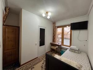 布哈拉Minorai Xurd的一间卧室配有一张床、一台电视和一个窗口