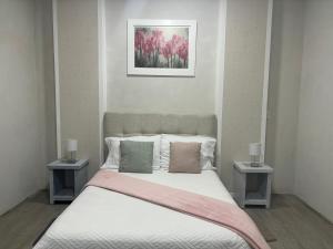 San Mateo XolocHotel Del Real的一间卧室配有一张带两张边桌的床