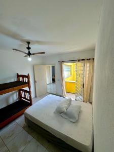 蒙加瓜Hostel Encanto de Mongaguá的一间卧室配有一张床和吊扇