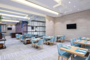 沙迦Four Points by Sheraton Sharjah的一间带桌椅和电视的用餐室