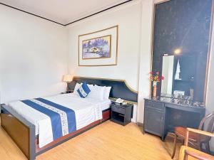 胡志明市New Star Inn Boutique Hotel-Near Bến Thành Market的酒店客房配有一张床铺和一张桌子。