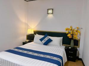 胡志明市New Star Inn Boutique Hotel-Near Bến Thành Market的一间卧室配有一张带蓝色和白色枕头的床