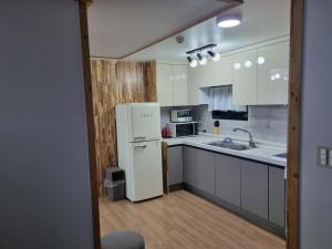 西归浦市JEJU Amoje的厨房配有白色家电和白色冰箱