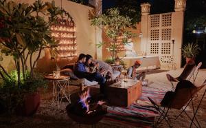 焦特布尔The Ajit Bhawan - A Palace Resort的一群人坐在客厅的火炉旁