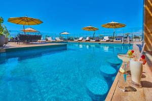 恩塞纳达港City Express Plus by Marriott Ensenada的一个带椅子和遮阳伞的游泳池