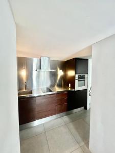 埃斯特角城Apartamento en Edificio YOO Punta del Este的厨房配有木制橱柜、水槽和炉灶。