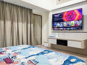 峇株巴辖UG Homestay BP - Netflix & 4 Air-Con Rooms的一间卧室配有一张床和一台平面电视