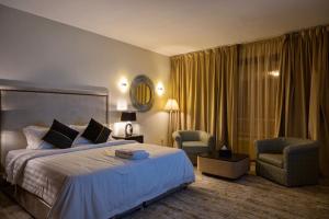 巴勒如拉斯Ghodran Hotel and Resort的酒店客房,配有一张床和两把椅子