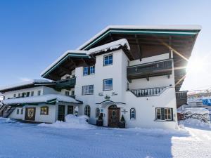 蒂罗尔-基希贝格Alpen Glück Villa Lisa的一座白色的大建筑,地面上积雪