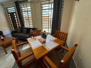 多多马Suji House的客厅配有木桌和椅子