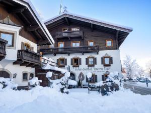 蒂罗尔-基希贝格Alpen Glück Hotel Unterm Rain garni的一座被雪覆盖的建筑,周围积雪覆盖