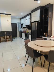 峇株巴辖UG Homestay BP - Netflix & 4 Air-Con Rooms的厨房以及带桌椅的用餐室。