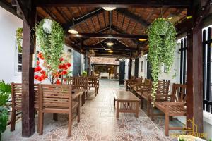 头顿Fullhouse Vũng Tàu Hotel TPVT的一间带木椅和桌子的餐厅以及鲜花