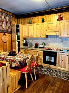 布吕松Fionisco - Giardino privato con vista sulle Alpi的厨房配有木制橱柜和桌椅