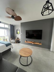 乌姆德洛蒂Beachfront Umdloti Resort 303的一间卧室配有一张床、一张桌子和一台电视。