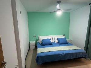 科蒂略Casa Teri - La Concha的一间卧室拥有蓝色的墙壁,配有一张带蓝色枕头的床。