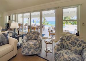总督港Pineapple House home的带沙发和椅子的客厅以及天井。