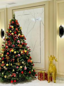 撒马尔罕Turon Lux Hotel的客厅里装有金色圣诞饰物的圣诞树